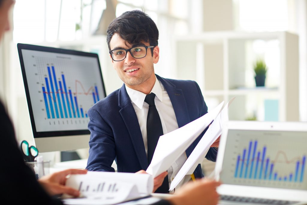 Successful financier showing some papers to co-worker during discussion